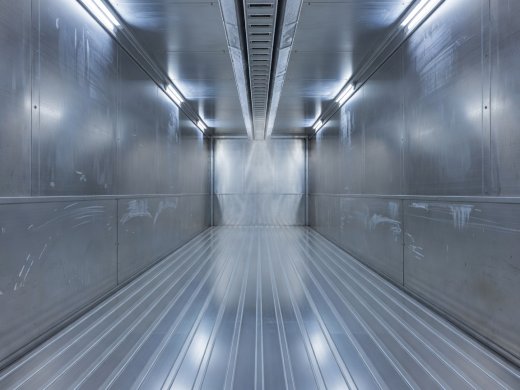 Interior of an empty refrigerated container showing extruded aluminum T-bar flooring, scuff liners, and ceiling air delivery chute